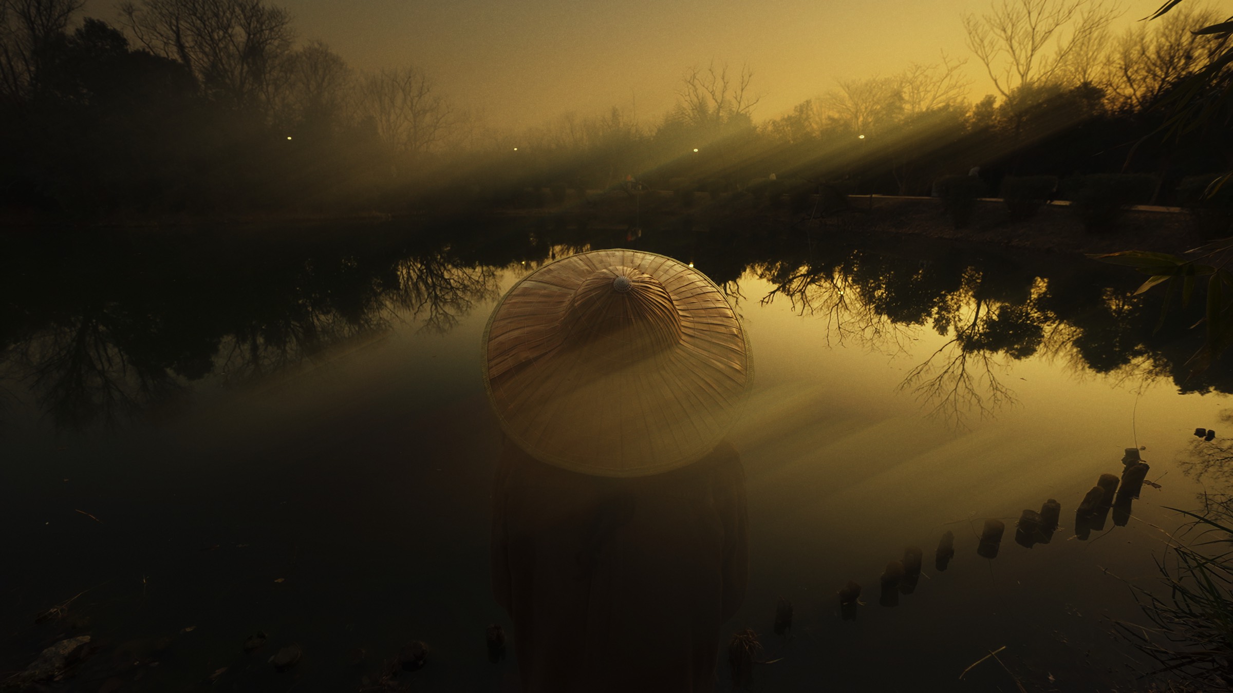 Figure in a wide-brimmed hat standing in a lake at dusk, with ShiftBox