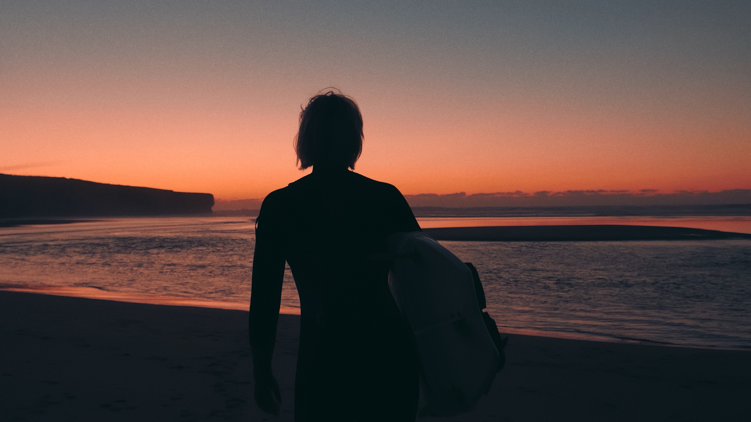 Surfer silhouette at dusk, before